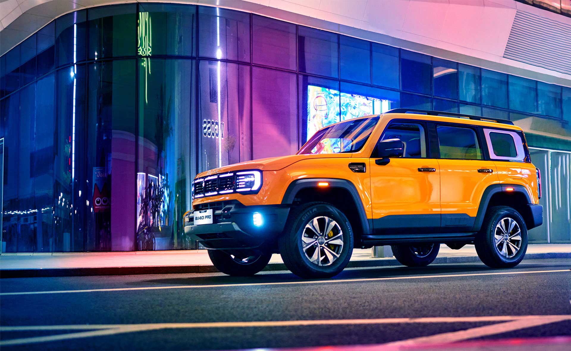 BAIC BJ40 Pro amarillo frente a un edificio iluminado